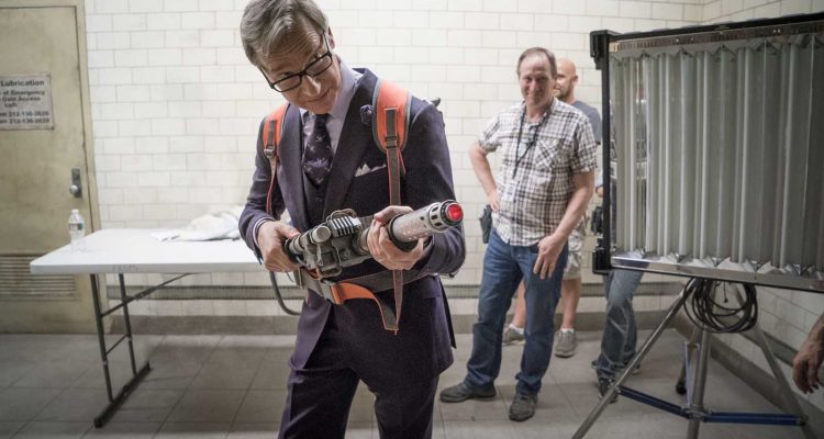 Director Paul Feig tries on the proton pack while propmaster Kirk Corwin and SFX supervisor Mark Hawker on the set of Columbia Pictures' GHOSTBUSTERS.