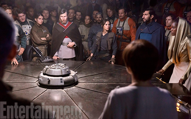 Rogue One: A Star Wars Story (2016) Felicity Jones (C) and Riz Ahmed (behind) - briefing room, with Felicity and the Senator Jebel (guy in red and grey), Senator Vaspar (guy in blue), Senator Pamlo (lady in gold). Also back of Mon Mothma's head